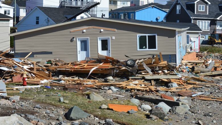 A broken building sits amid a pile of rubble