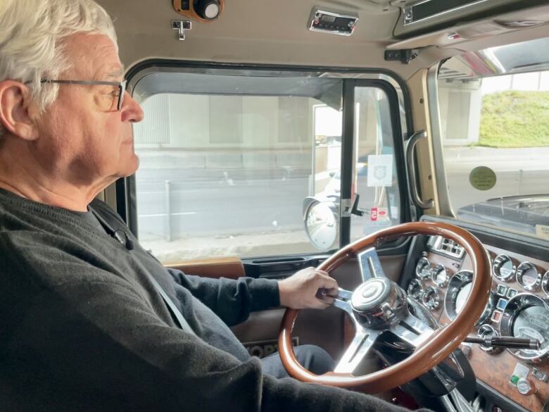 A man is sitting behind in a truck.