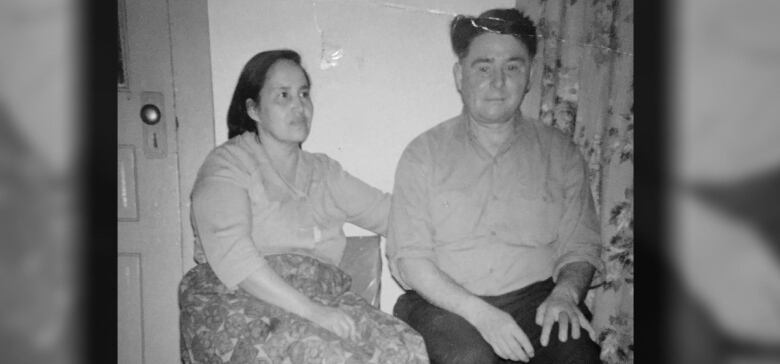 Older-looking photo of two people seated.