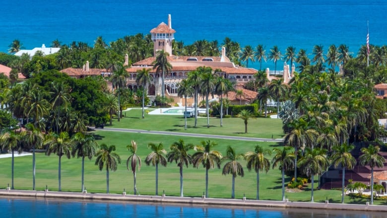 A photo from above a sprawling hotel complex with palm trees and the ocean visible. 