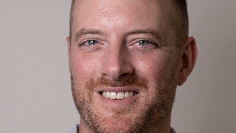 A close up shot of a person's face. He has a short beard.