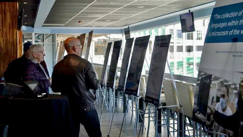 Regina residents examine information about a potential new indoor aquatics facility during public consultations presented by the catalyst committee at Mosaic Stadium.