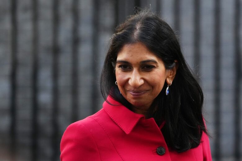 A woman in a red jacket smiles.