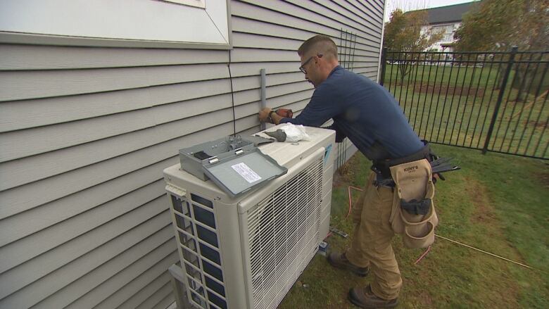 Man installs a heat pump.