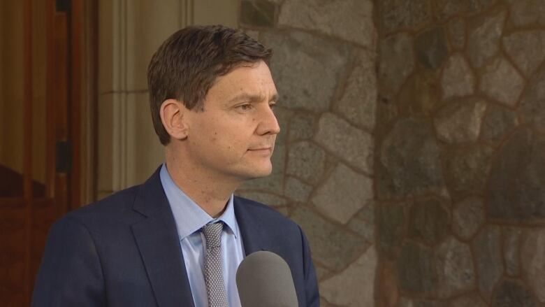 David Eby pictured answering media questions