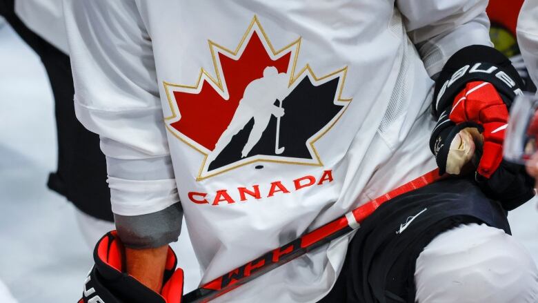 Athlete sports Hockey Canada logo while kneeling on the ice.