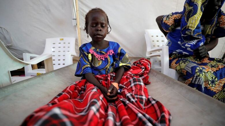 A young patient sits in bed at an MSF cholera treatment centre.