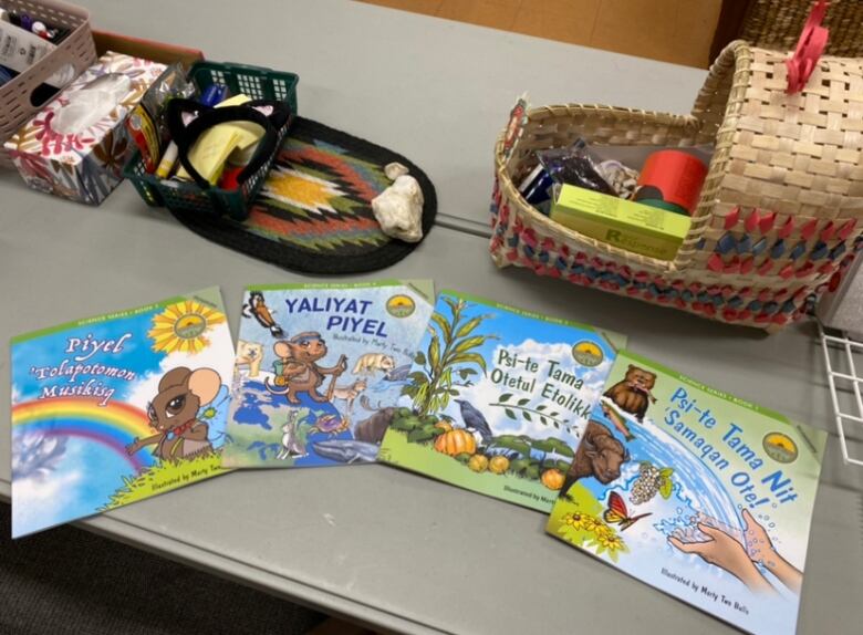 Four children's books spread out on a table.