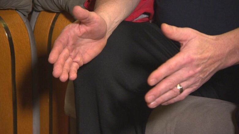 A closeup photo shows a man's hands.