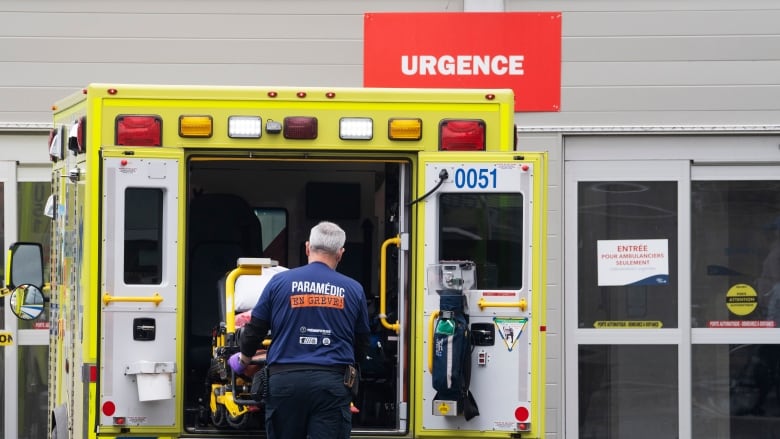 A paramedic loads his stretcher back into the ambulance.