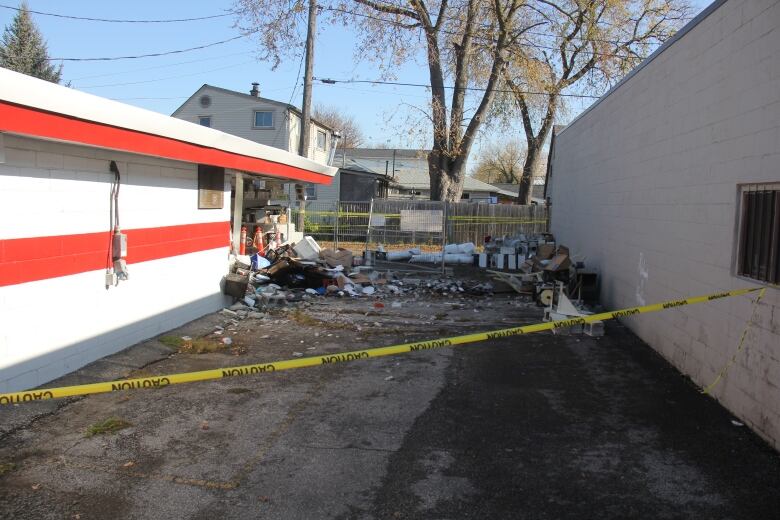 A hole in the side of a wall of a building with debris spilling out