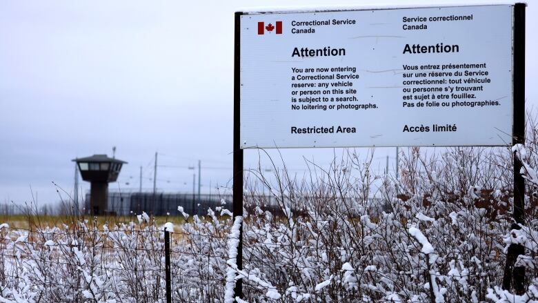 A big white sign near a guard tower. 