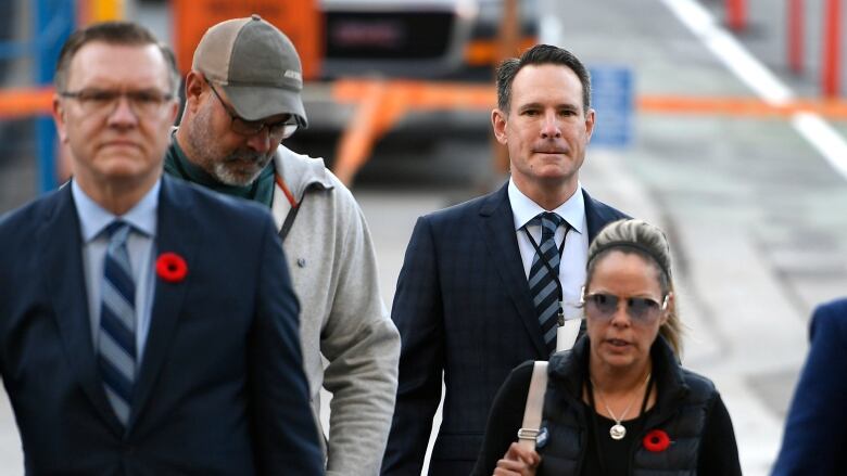 A group of four people walk outside.