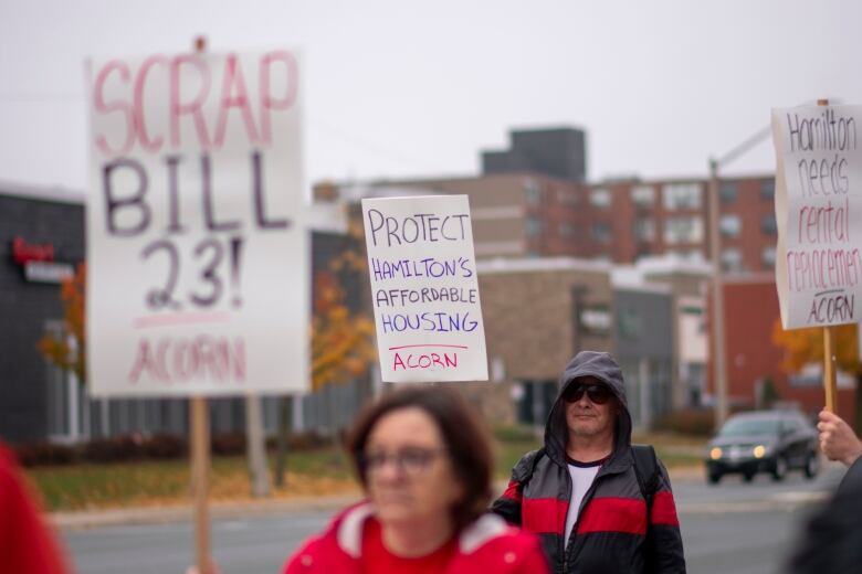 Three people standing outside with signs