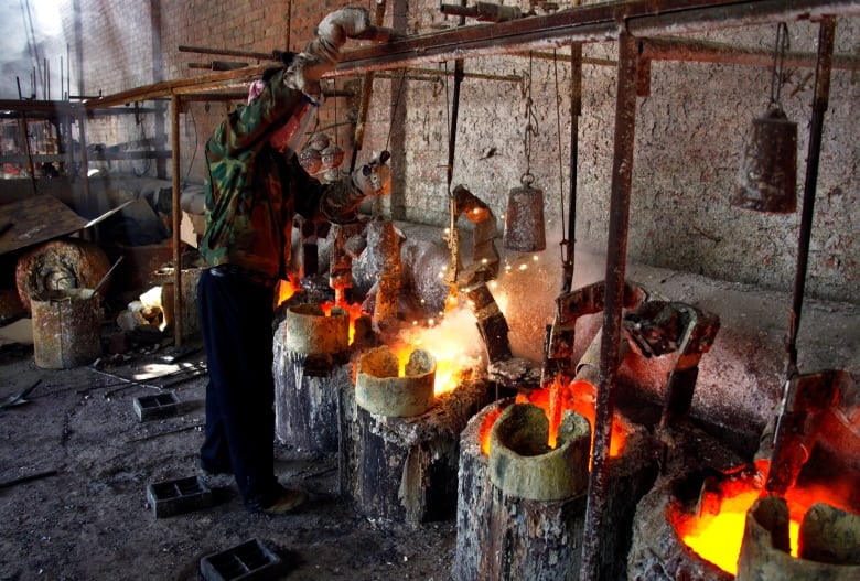 Man working over glowing-hot pots