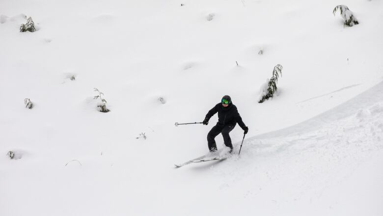 A person is pictured skiing against a mountain of snow.