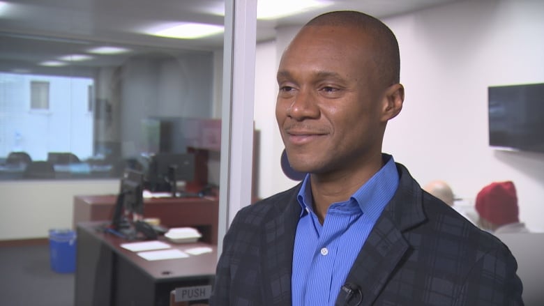 Man in a blue suit smiles.