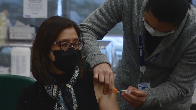 Dr. Eileen de Villa is getting a flu shot in her arm.