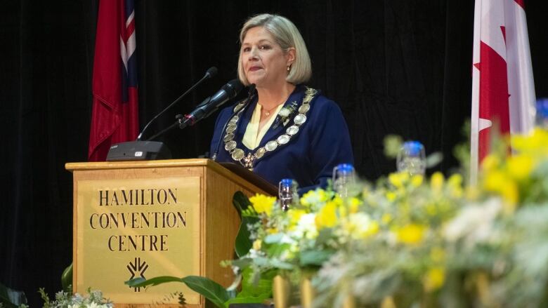 A woman stands at a podium.