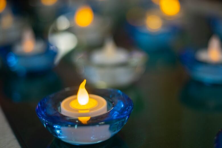 Tea lights sit in blue and white candle holders.