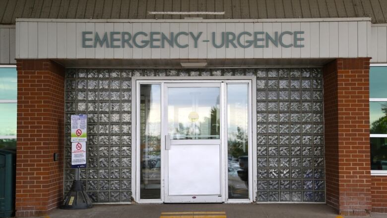 A glass door with the word 'emergency' overhead.