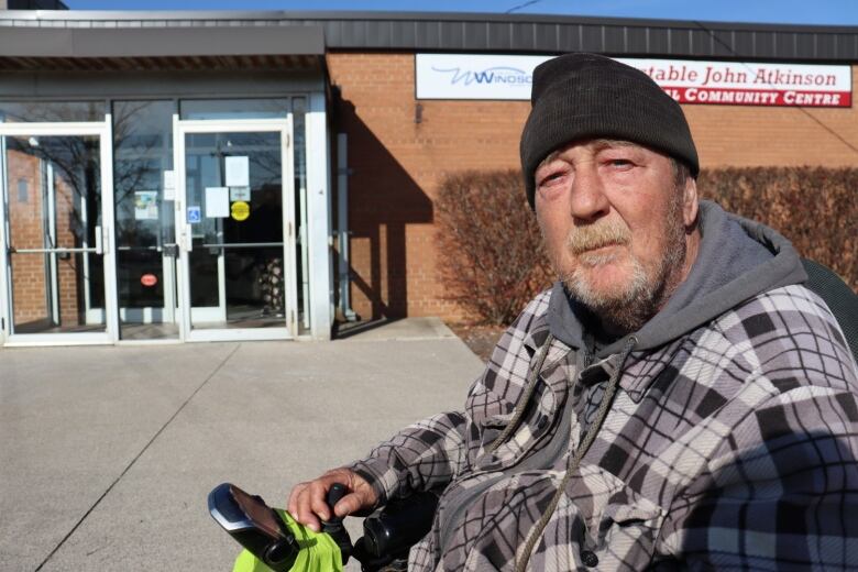 A man in a wheelchair is in front of the Constable John Atkinson Memorial Community Centre.