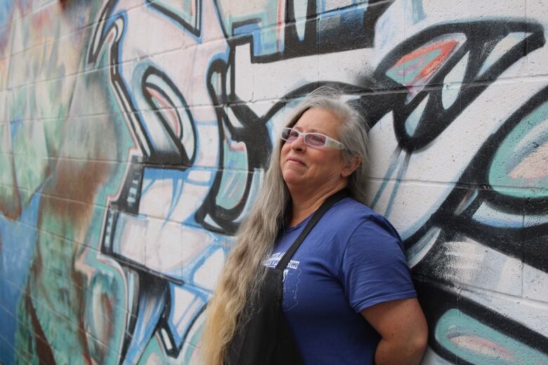 A woman in front of a wall.