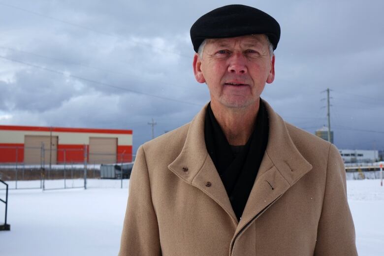 A man wearing a dark hat faces the camera.