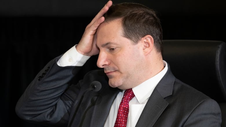 A man adjusts his hair.