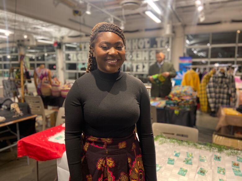 An African American woman smiles for the camera at an entrepreneur fair.