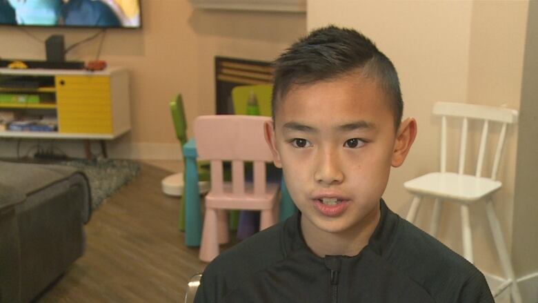 A young boy gestures as he speaks for the camera.