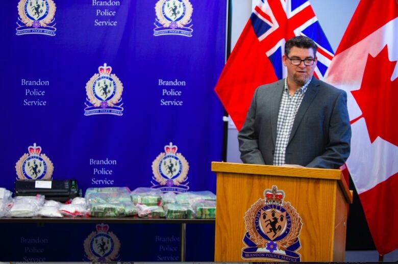 A man with a goatee speaks at a podium.