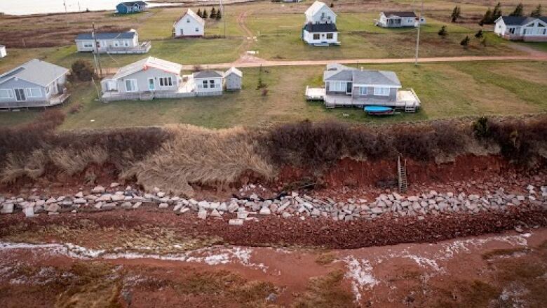 Aerial view of damage from Fiona in front of a row of cottages 