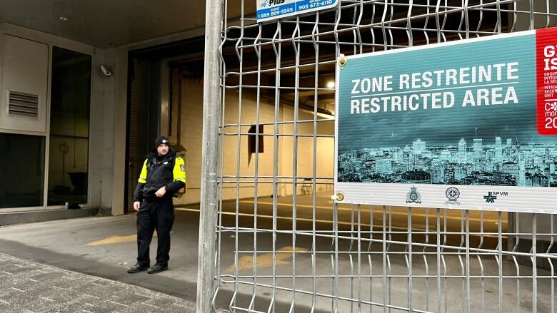 A police officer is standing in front of a garage.