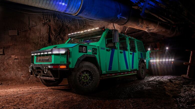 A large green vehicle in an underground mine.