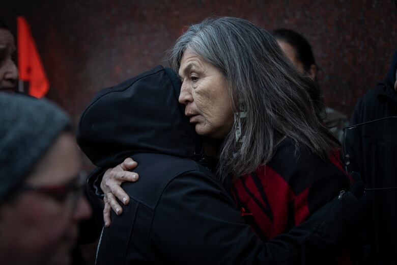 A woman hugs another person.