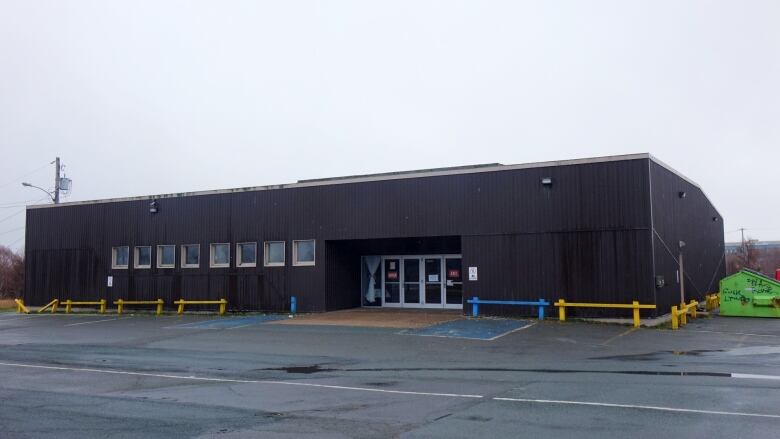 A one storey building and an empty parking lot.