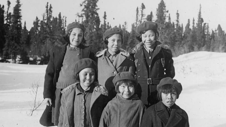 Photo shows six children who attended residential school posing in the winter.