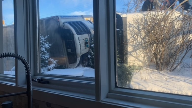 A semi-truck is visible through a window.