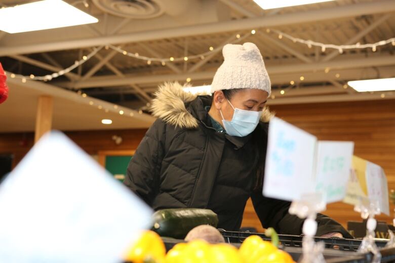 Mae Drilon looks through a selection of vegetables at a Fresh Routes mobile market in northwest Calgary. 