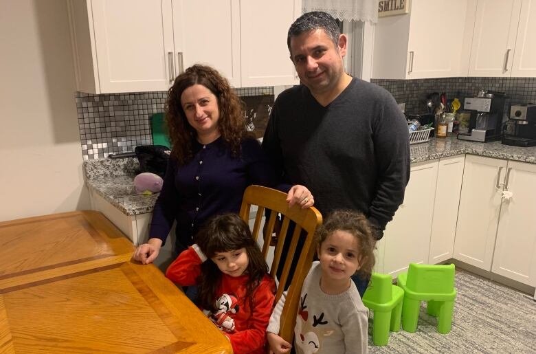 Family of four stands in their kitchen 