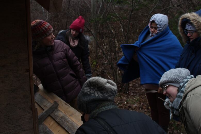 A group of people gather in Eleanor Wynn's backyard to learn about raising backyard birds.