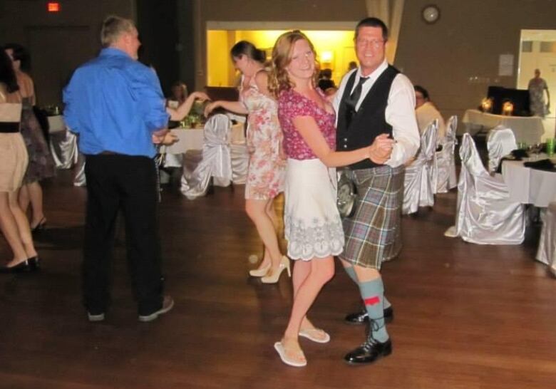 A woman and her father dance at a wedding.