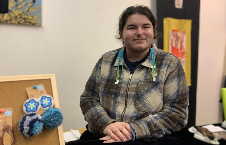 Indigenous beader sits at their craft booth