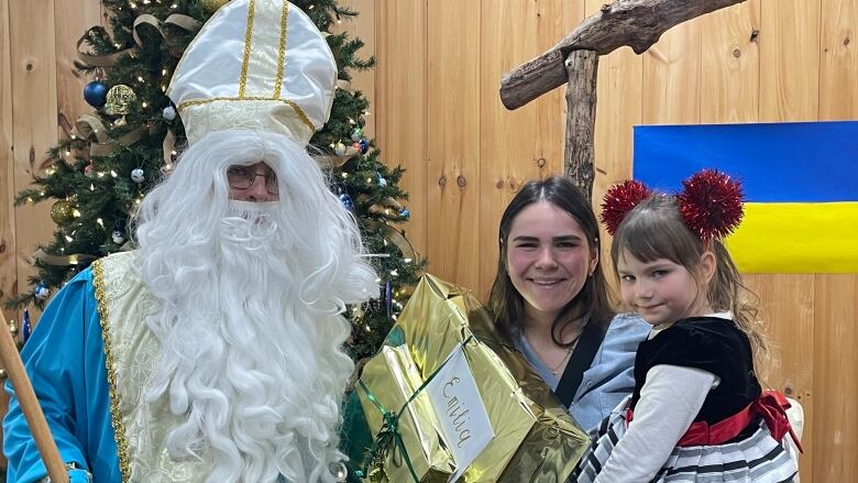 Vladyslav Khanyeyev dressed up as St. Nicholas and handed out gifts to Sasha Kival and daughter Emilia Vasglkovska. 