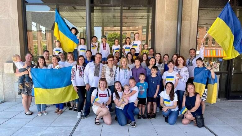 People with Ukrainian flags posing in Charlottetown in summer 2022.