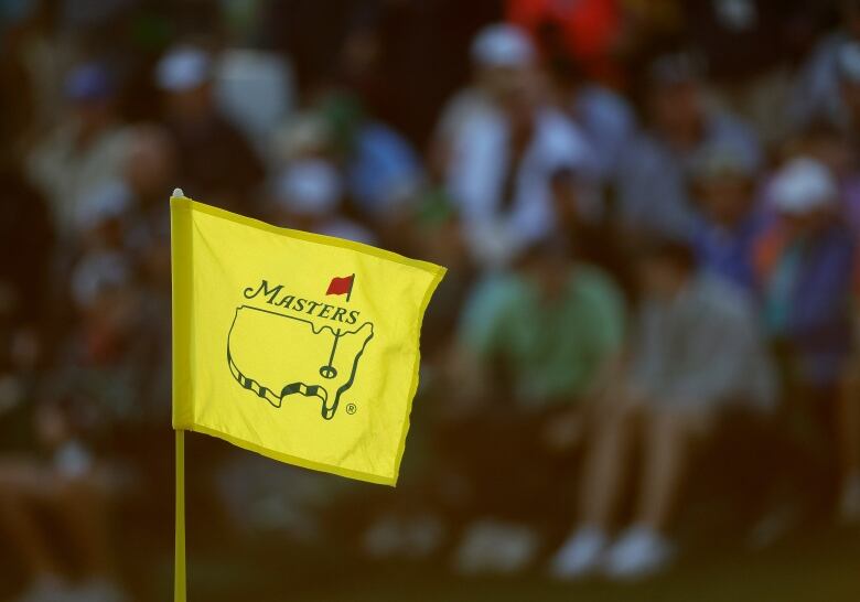 A yellow 'Masters' pin flag waves in the wind.