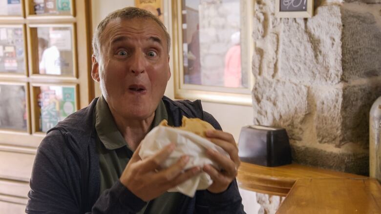 A man enthusiastically eats a sandwich. 