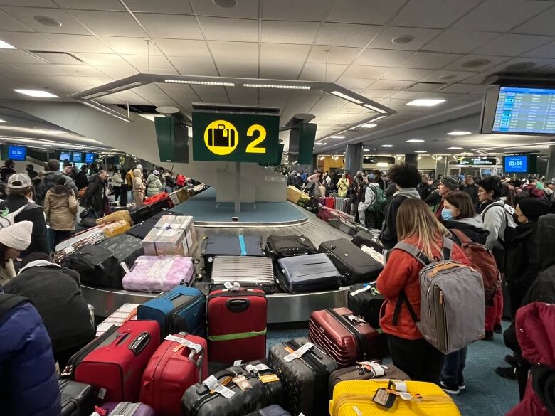 A mess of colourful luggage and frustrated passengers is pictured at a crowded baggage terminal inside Vancouver International Airport.