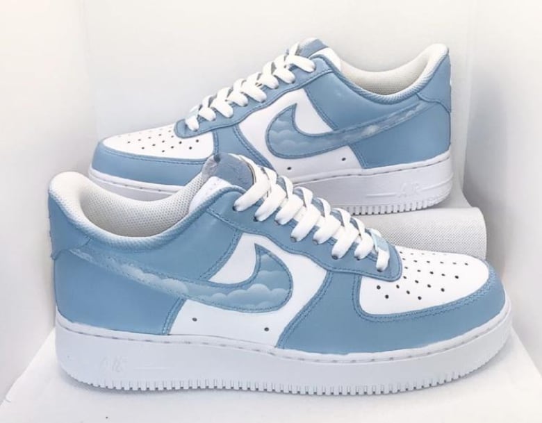 Sections of white sneakers have been painted with sky blue, and the Nike swooshes have been filled in with airbrushed clouds.